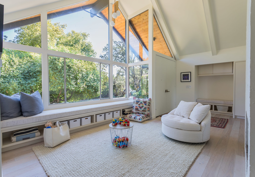 Photo of a midcentury gender-neutral kids' playroom in San Francisco with white walls, light hardwood floors and beige floor.