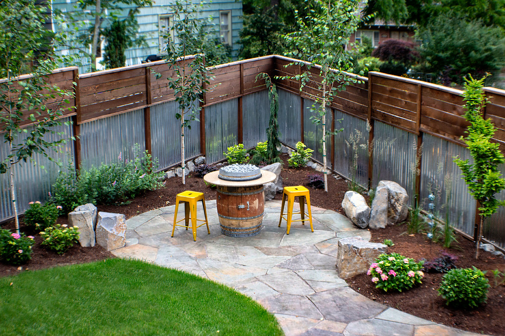 Design ideas for a mid-sized modern backyard full sun garden in Portland with natural stone pavers.