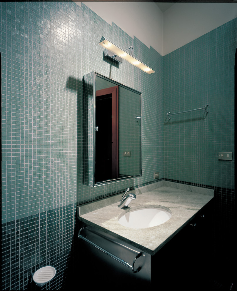 This is an example of a mid-sized 3/4 bathroom in Milan with open cabinets, an alcove shower, a two-piece toilet, green tile, grey walls, mosaic tile floors, a drop-in sink, marble benchtops, green floor, a hinged shower door and green benchtops.