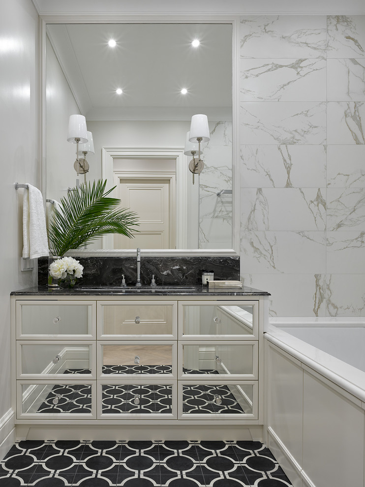 Inspiration for a mid-sized transitional master bathroom in Moscow with white cabinets, gray tile, marble benchtops, glass-front cabinets, an undermount tub, white walls, an undermount sink and black floor.