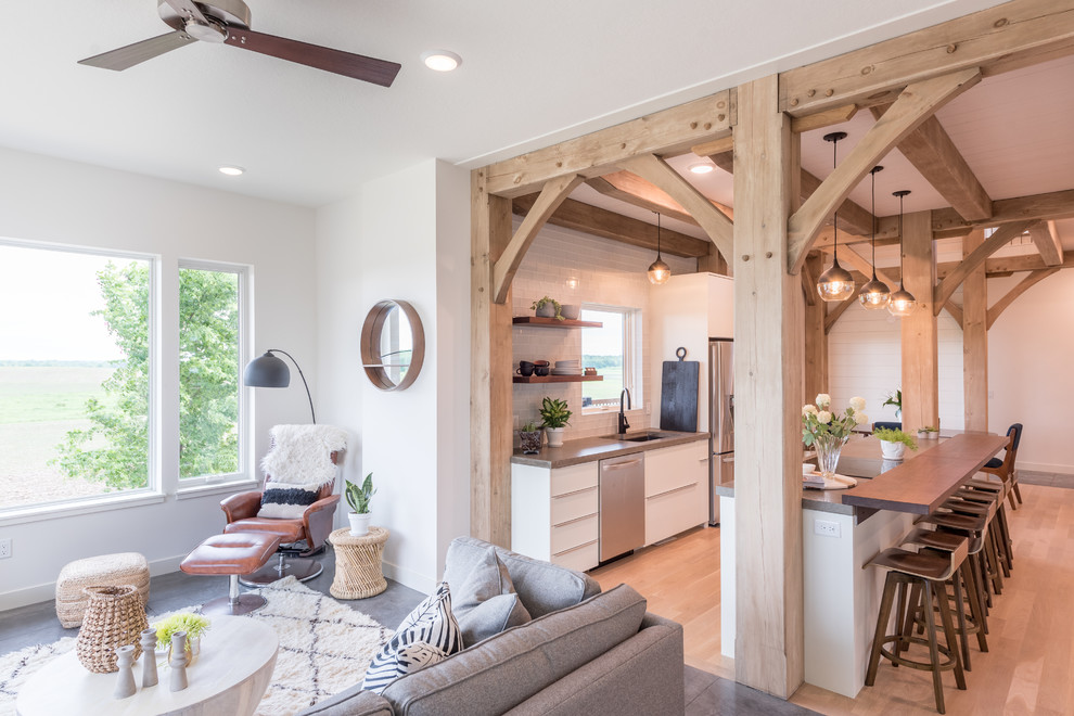 Example of a mid-sized cottage single-wall medium tone wood floor and brown floor open concept kitchen design in Minneapolis with an undermount sink, flat-panel cabinets, white cabinets, concrete countertops, white backsplash, subway tile backsplash, stainless steel appliances, an island and gray countertops