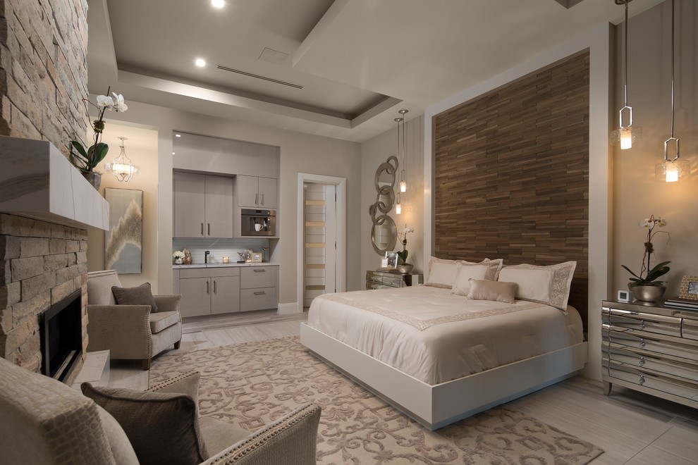 Design ideas for a large contemporary master bedroom in Orlando with a standard fireplace, a stone fireplace surround, beige walls and beige floor.