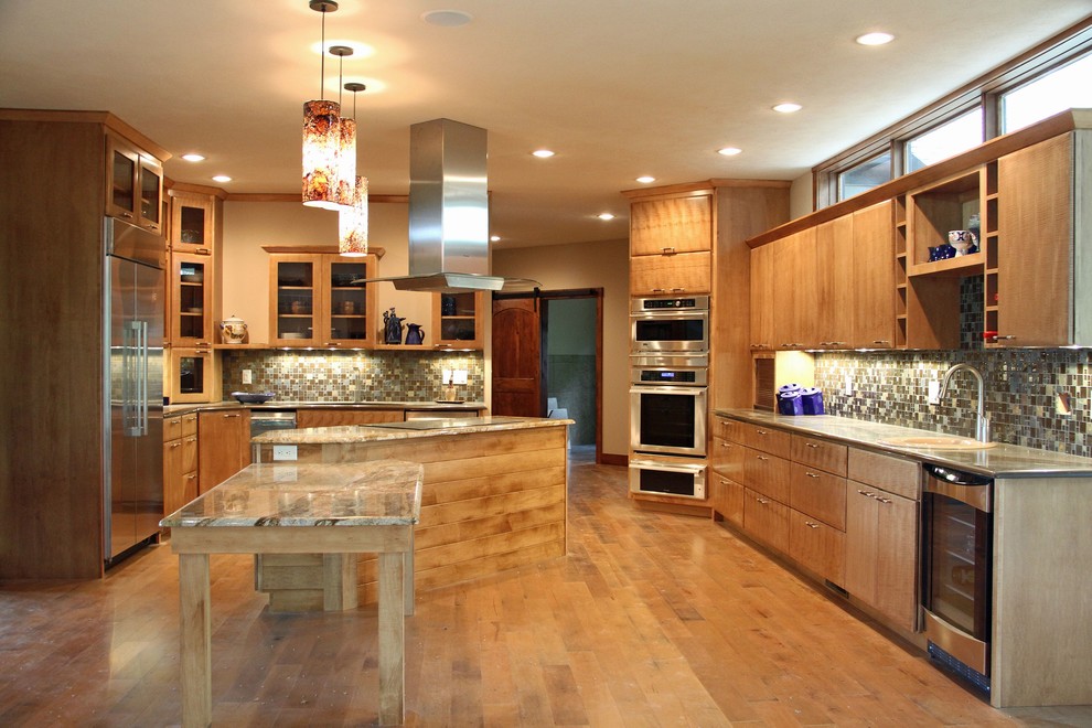 Photo of a large traditional u-shaped kitchen in St Louis with flat-panel cabinets, light wood cabinets, stainless steel appliances, light hardwood floors and with island.