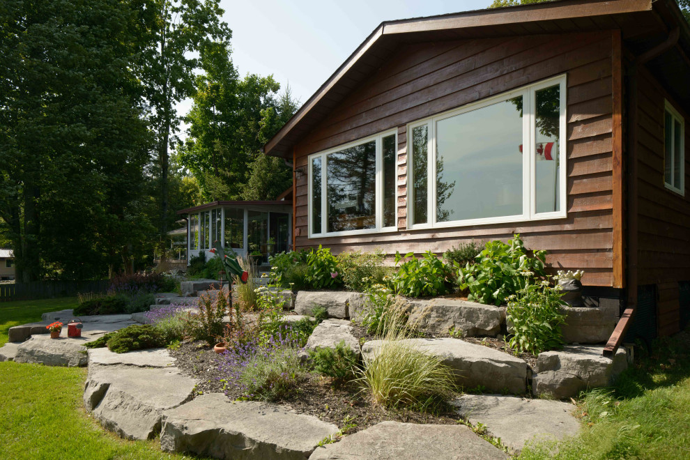 This is an example of a bohemian front full sun garden for summer in Other with a rockery and natural stone paving.
