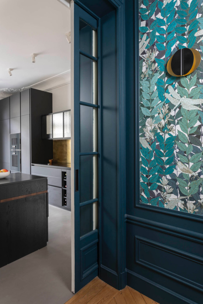 Inspiration for a large contemporary single-wall separate kitchen in Paris with an undermount sink, black cabinets, granite benchtops, metallic splashback, panelled appliances, concrete floors, with island, grey floor and black benchtop.