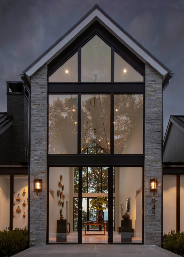 Свежая идея для дизайна: огромный, двухэтажный, серый частный загородный дом в стиле модернизм с облицовкой из камня, металлической крышей и коричневой крышей - отличное фото интерьера