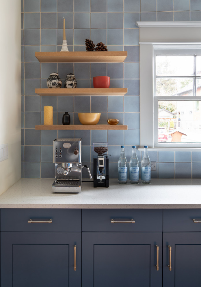 Arts and crafts galley kitchen in Portland with blue cabinets, multi-coloured splashback, subway tile splashback, stainless steel appliances and white benchtop.