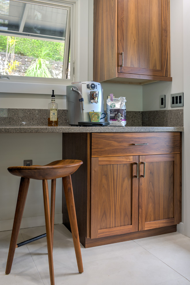Small transitional single-wall seated home bar in Hawaii with flat-panel cabinets, medium wood cabinets, granite benchtops, grey splashback and porcelain floors.