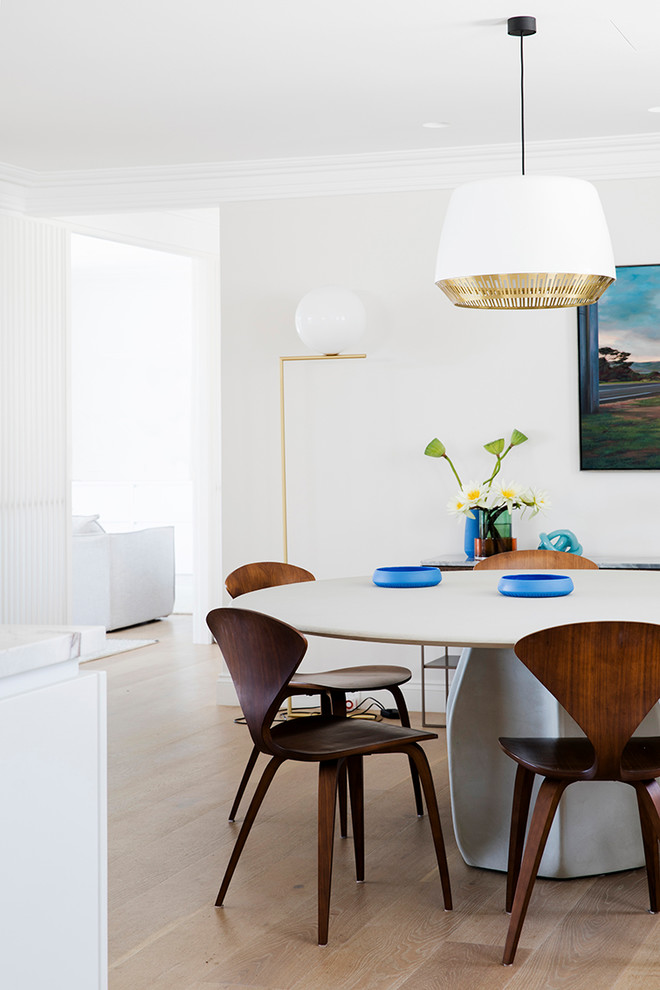 Contemporary dining room in Sydney with white walls, medium hardwood floors and brown floor.