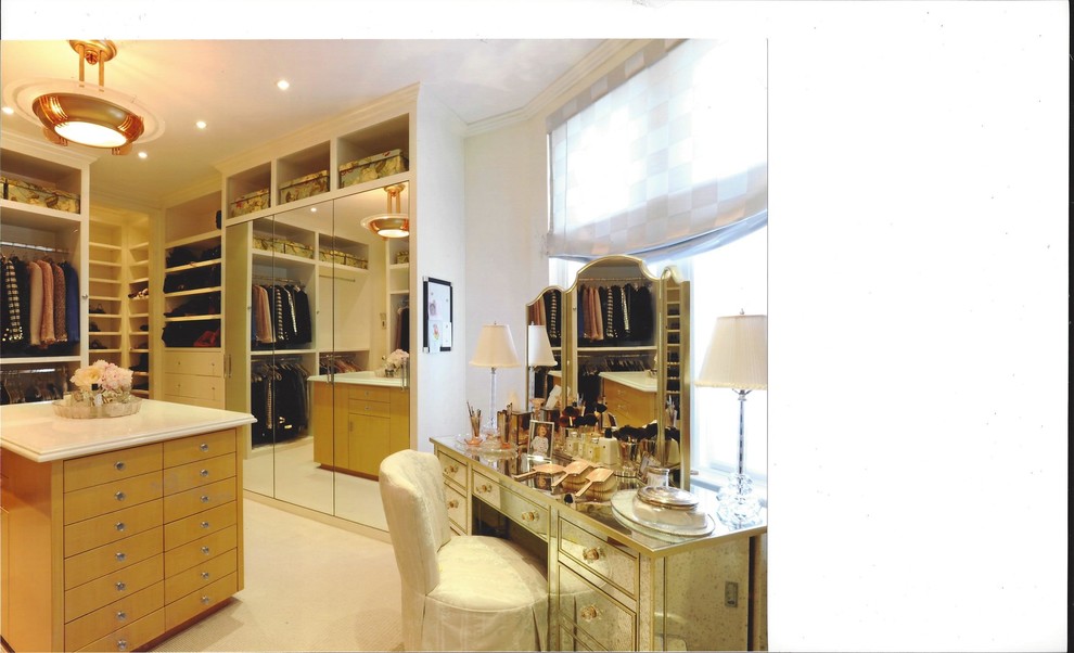 Photo of an expansive traditional women's dressing room in New York with flat-panel cabinets, light wood cabinets and carpet.