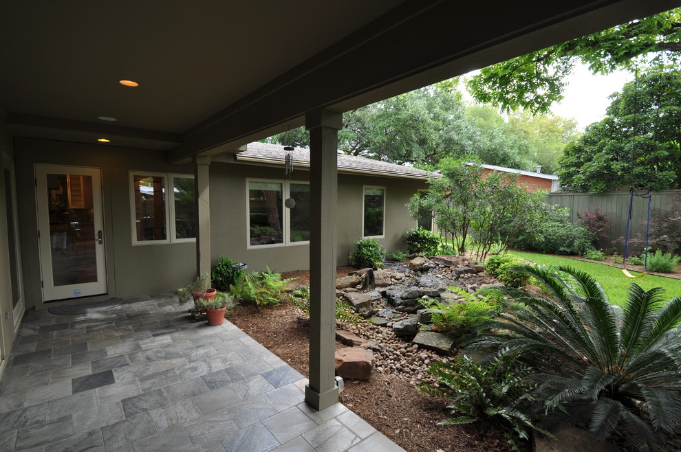 Design ideas for a midcentury exterior in Austin with stone veneer.