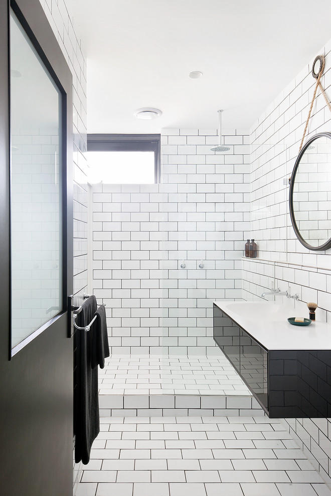 Inspiration for a small contemporary master bathroom in Melbourne with black cabinets, an open shower, subway tile, white walls, ceramic floors, white tile, a wall-mount sink, laminate benchtops, flat-panel cabinets and an open shower.