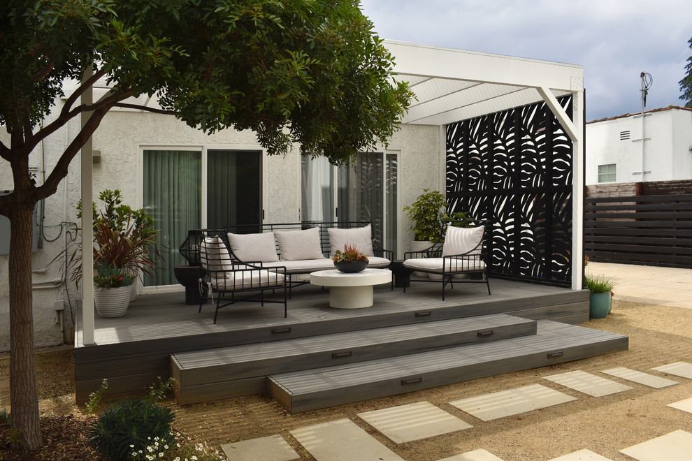 Photo of a mid-sized contemporary front yard full sun xeriscape for spring in Los Angeles with a fire feature and concrete pavers.