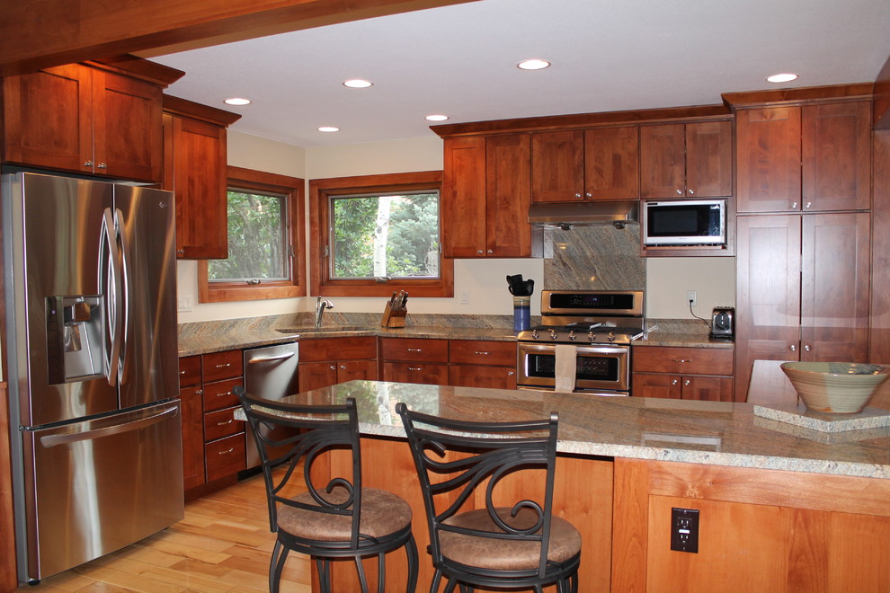 Eat-in kitchen - large transitional galley light wood floor eat-in kitchen idea in Denver with an undermount sink, flat-panel cabinets, dark wood cabinets, granite countertops, stainless steel appliances and a peninsula