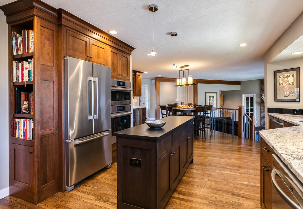 Photo of a mid-sized contemporary u-shaped eat-in kitchen in Denver with an undermount sink, shaker cabinets, medium wood cabinets, granite benchtops, black splashback, stone slab splashback, stainless steel appliances, medium hardwood floors and with island.