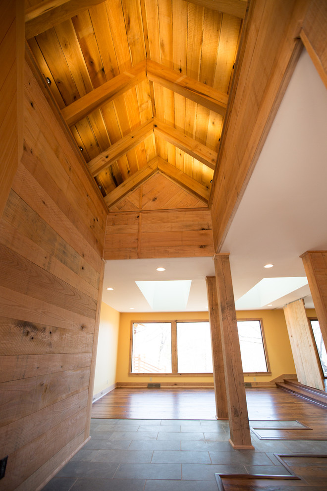 Hallway - large rustic medium tone wood floor hallway idea with brown walls
