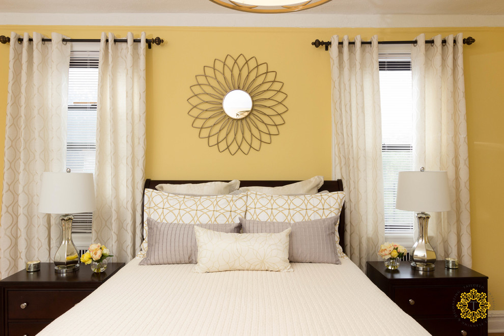 Photo of a large transitional master bedroom in New York with yellow walls, light hardwood floors and no fireplace.