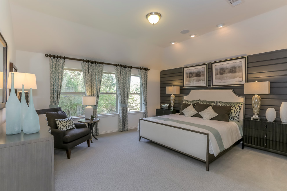 This is an example of a large transitional master bedroom in Houston with white walls and carpet.