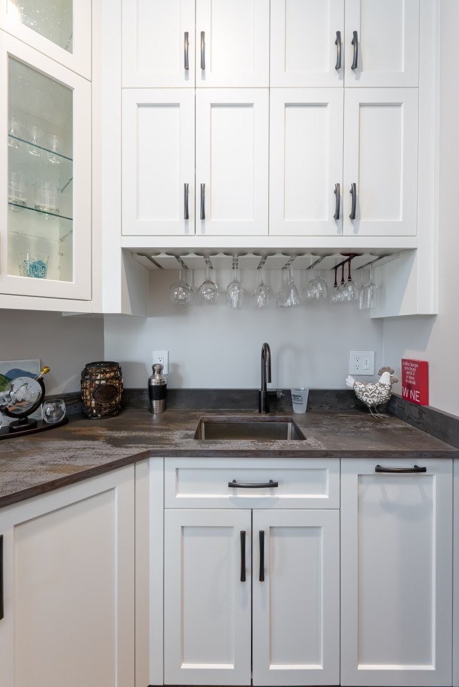 Large transitional medium tone wood floor and brown floor open concept kitchen photo with a double-bowl sink, flat-panel cabinets, white cabinets, quartzite countertops, beige backsplash, stainless steel appliances, an island and beige countertops