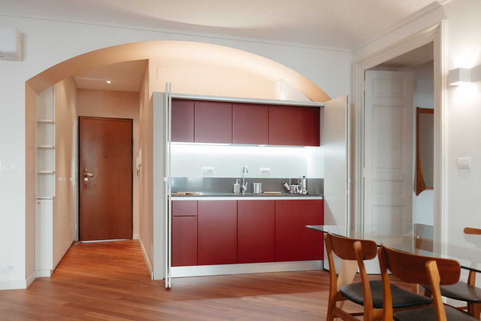 Small contemporary single-wall open plan kitchen in Turin with beaded inset cabinets, red cabinets, quartz benchtops, no island and black benchtop.