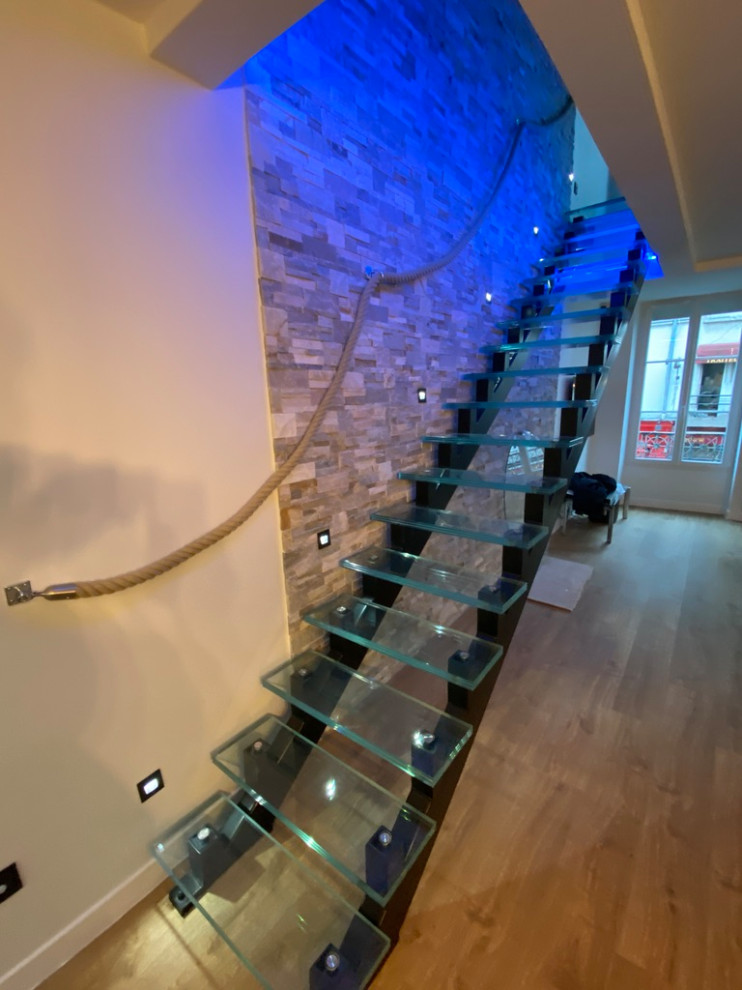 Imagen de escalera recta actual grande con escalones de vidrio, contrahuellas de vidrio y ladrillo