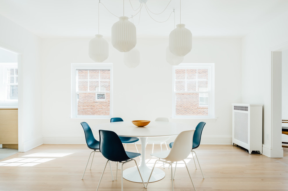 Inspiration for a mid-sized scandinavian dining room in Salt Lake City with white walls, light hardwood floors, beige floor and no fireplace.