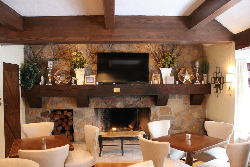 Inspiration for a large country kitchen/dining combo in Nashville with yellow walls, light hardwood floors, a standard fireplace and a stone fireplace surround.