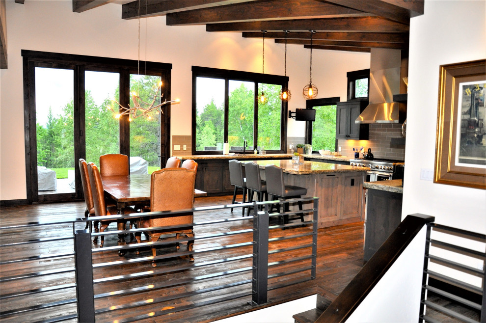 Open concept kitchen - mid-sized rustic medium tone wood floor, brown floor and wood ceiling open concept kitchen idea with recessed-panel cabinets, dark wood cabinets, granite countertops, gray backsplash, subway tile backsplash, stainless steel appliances, an island and brown countertops