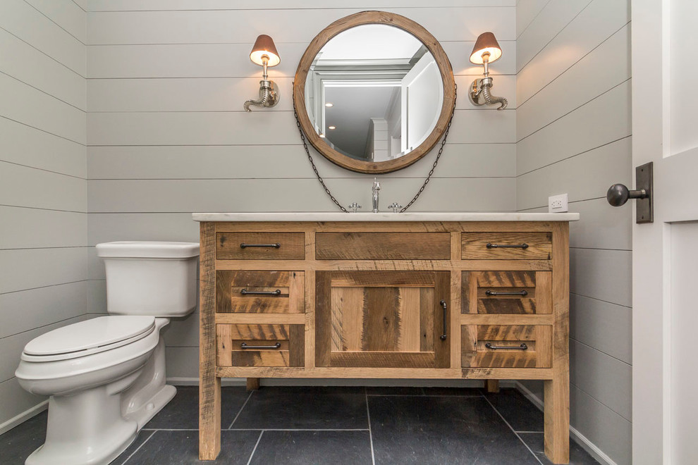 Design ideas for a mid-sized country 3/4 bathroom in Cleveland with shaker cabinets, medium wood cabinets, a two-piece toilet, grey walls, ceramic floors, an undermount sink and marble benchtops.