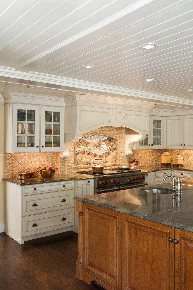 This is an example of a traditional kitchen in Boston with glass-front cabinets, beige cabinets, granite benchtops and multi-coloured splashback.