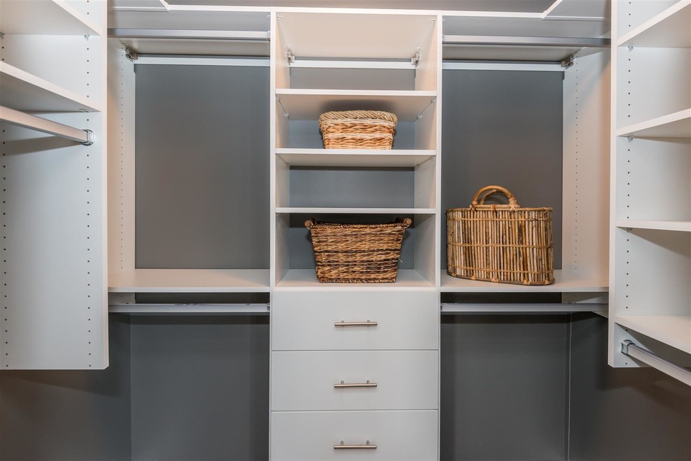 Walk-in closet - mid-sized transitional gender-neutral medium tone wood floor and brown floor walk-in closet idea with flat-panel cabinets and white cabinets