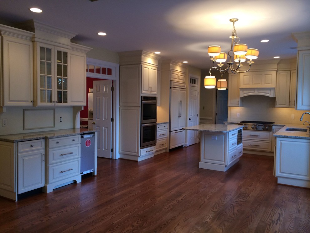 Eat-in kitchen - rustic l-shaped medium tone wood floor eat-in kitchen idea in DC Metro with an undermount sink, raised-panel cabinets, white cabinets, marble countertops, white backsplash, stone slab backsplash, stainless steel appliances and an island