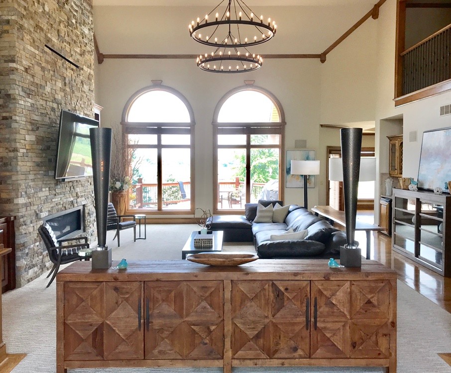 Photo of an expansive transitional open concept living room with a hanging fireplace, a stone fireplace surround and a built-in media wall.
