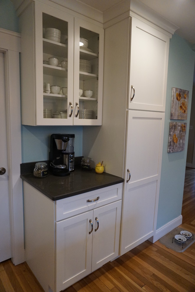 Mid-sized transitional u-shaped medium tone wood floor eat-in kitchen photo in Boston with an undermount sink, shaker cabinets, gray cabinets, quartz countertops, black backsplash, stainless steel appliances and an island