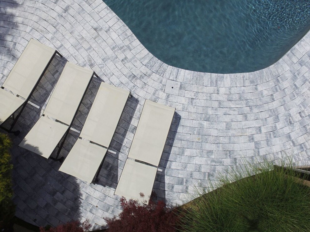 Pool - large backyard stone and custom-shaped lap pool idea in New York