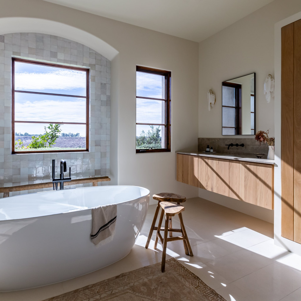 Exemple d'une salle de bain chic en bois brun avec un placard à porte plane, une baignoire indépendante, un mur blanc, un lavabo encastré, un sol gris, un plan de toilette gris, meuble simple vasque et meuble-lavabo suspendu.