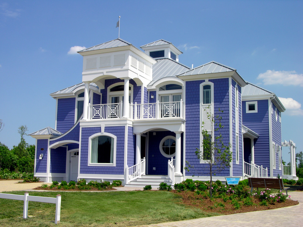 Inspiration for a large beach style two-storey purple house exterior in Other with wood siding, a hip roof and a metal roof.