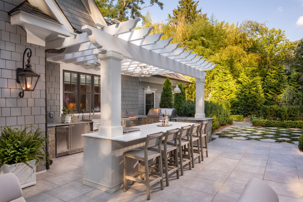 This is an example of an expansive transitional backyard patio in DC Metro with concrete pavers and a pergola.