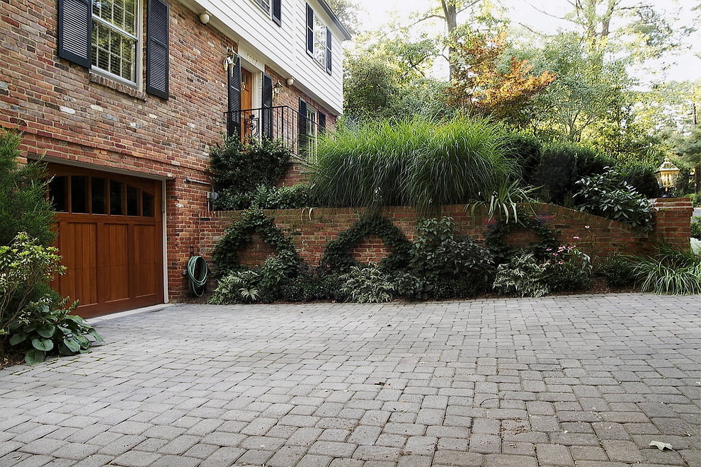 Design ideas for a mid-sized transitional front yard full sun driveway for summer in DC Metro with a garden path and concrete pavers.