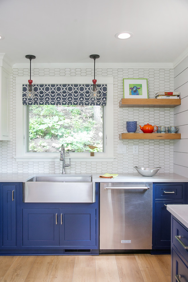 Inspiration for a mid-sized country u-shaped linoleum floor and brown floor enclosed kitchen remodel in Milwaukee with a farmhouse sink, beaded inset cabinets, blue cabinets, quartz countertops, white backsplash, ceramic backsplash, stainless steel appliances and gray countertops