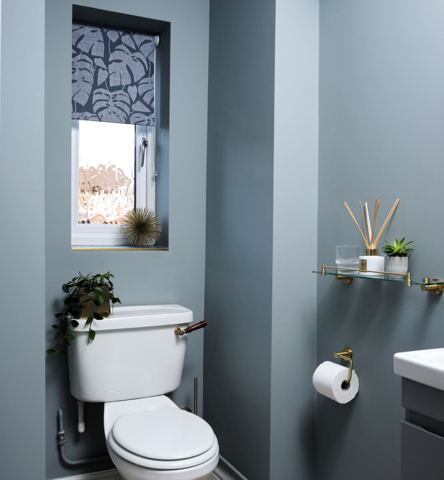 Bild på ett litet funkis grå grått badrum, med släta luckor, grå skåp, en dusch i en alkov, grå kakel, porslinskakel, grå väggar, vinylgolv, ett väggmonterat handfat, kaklad bänkskiva och brunt golv