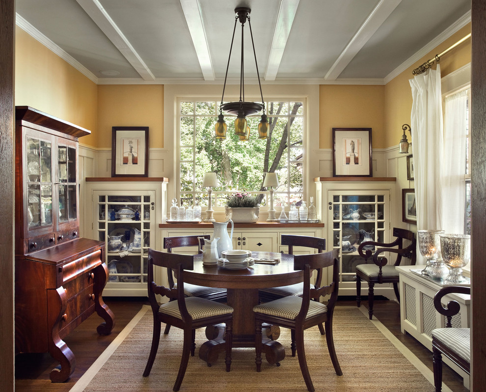 Traditional separate dining room in New York with yellow walls and dark hardwood floors.