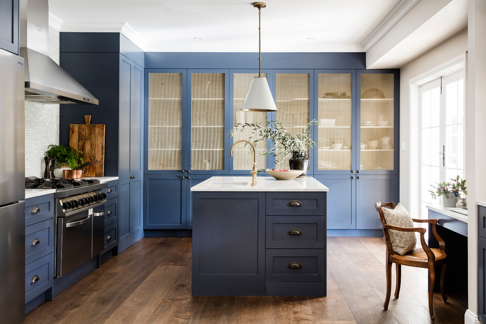 This is an example of a large transitional eat-in kitchen in Sydney with a farmhouse sink, shaker cabinets, blue cabinets, marble benchtops, grey splashback, marble splashback, stainless steel appliances, dark hardwood floors and with island.