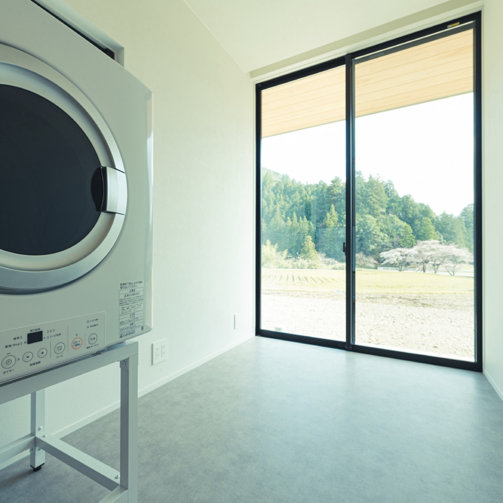 This is an example of a laundry room in Other with white walls, ceramic floors, a side-by-side washer and dryer, grey floor, wallpaper and wallpaper.