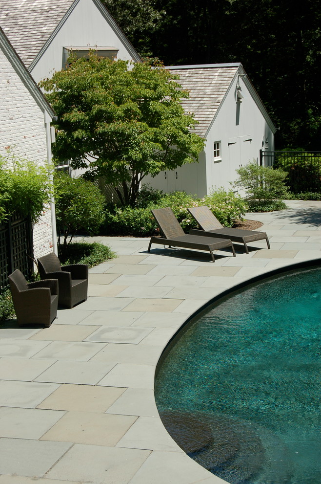 Inspiration for a mid-sized traditional backyard round pool in Boston with natural stone pavers.