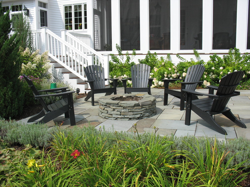 Inspiration for a traditional side yard patio in Burlington with natural stone pavers, a fire feature and no cover.