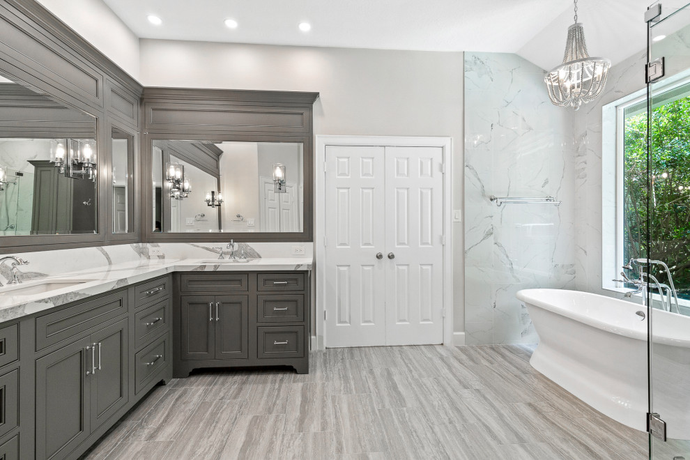 Freestanding bathtub - mid-sized transitional master white tile and porcelain tile ceramic tile, gray floor and double-sink freestanding bathtub idea in Houston with recessed-panel cabinets, gray cabinets, gray walls, an undermount sink, quartz countertops, a hinged shower door, white countertops and a built-in vanity