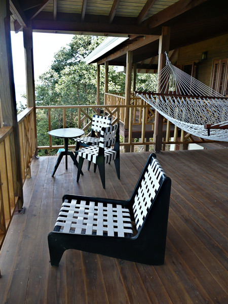 This is an example of a large tropical verandah in Other with a roof extension and decking.