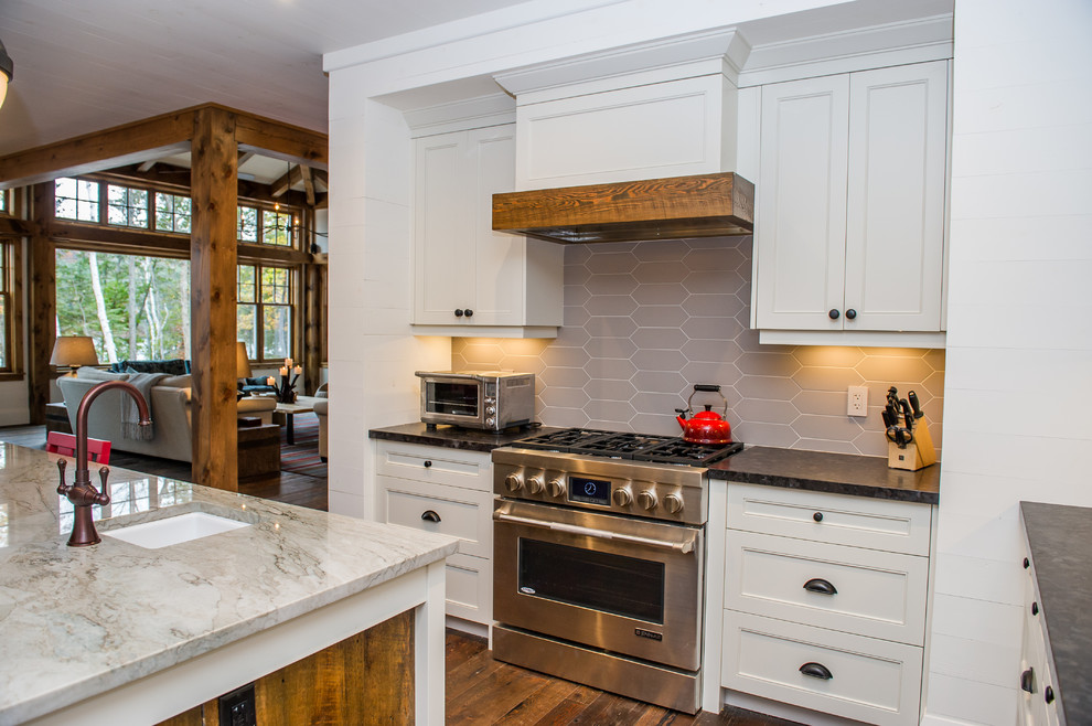 Photo of a country u-shaped eat-in kitchen in Toronto with a farmhouse sink, shaker cabinets, white cabinets, granite benchtops, ceramic splashback, stainless steel appliances, medium hardwood floors and with island.