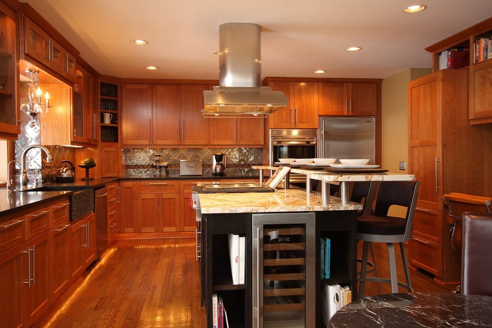 Example of a large transitional l-shaped medium tone wood floor and brown floor eat-in kitchen design in Houston with a farmhouse sink, shaker cabinets, medium tone wood cabinets, granite countertops, brown backsplash, stainless steel appliances, an island and brown countertops